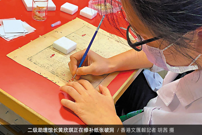 香港中央圖書館二級(jí)助理館長(zhǎng)黃欣琪正在修補(bǔ)紙張破洞/香港文匯報(bào)記者 胡茜 攝